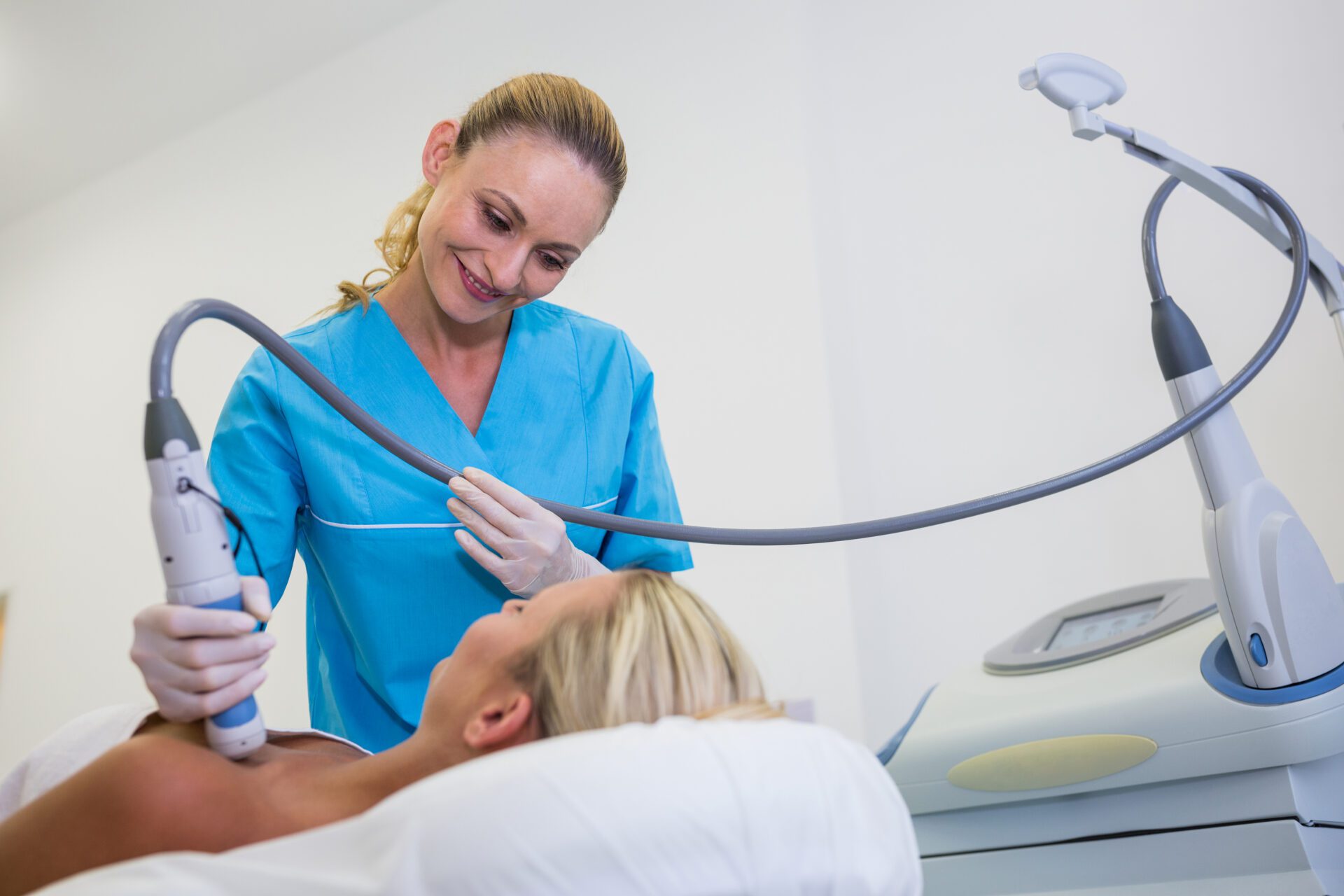 Woman receiving laser epilation treatment on her body at beauty salon